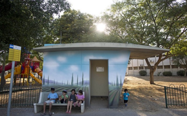 Israeli children sit next to a concrete protective shelter painted by Israeli artist Eliasaf Myara in the village of Kfar Maimon, located a few kilometers from the border with the Gaza Strip, Israel, 14 June 2015. The Israeli Defense Ministry has placed hundreds of small concrete protective shelters to all towns located near the Gaza Strip to protect its citizens from incoming rockets. On 08 July 2015, Israel will mark one year since the 2014 IsraelGaza conflict, also known as Operation Protective Edge.